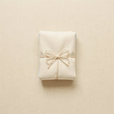 A folded baby garment tied like a small parcel, representing free delivery